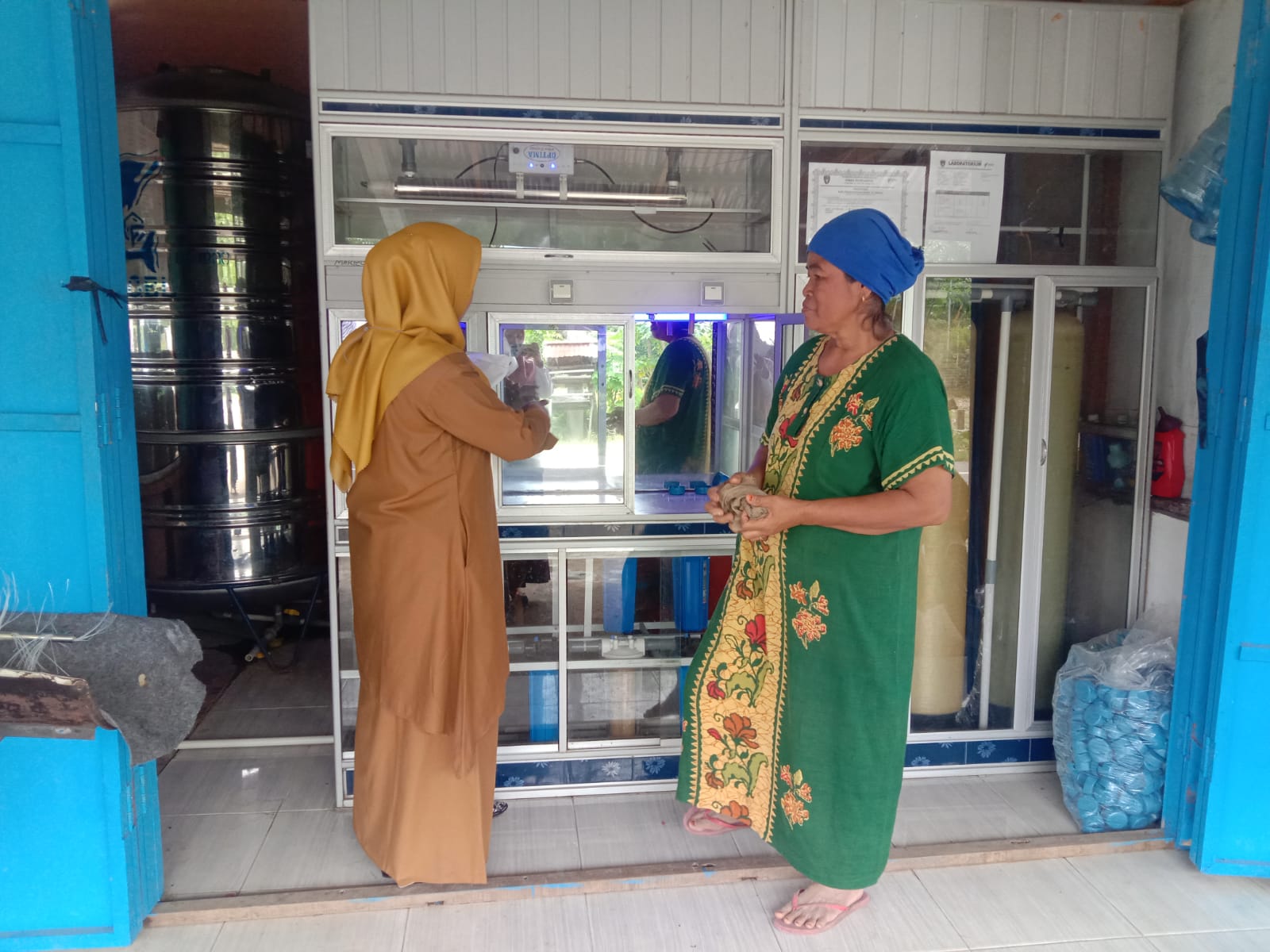 Petugas kesehatan lingkungan UPT Puskesmas Tarusan Riza Sari Putri dan Lexsi melakukan pemeriksaan D